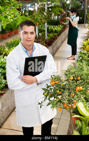 Scientist holding un presse-papiers dans une serre Banque D'Images