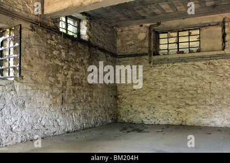 Salle vide des fenêtres cassées et mur blanc texturé. Usine abandonnée de l'intérieur. Banque D'Images