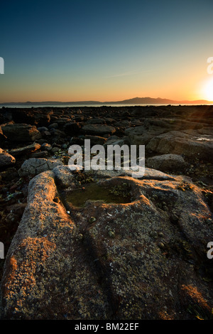 Coucher de soleil sur la plage d'Ardrossan vu de l'Arran Banque D'Images