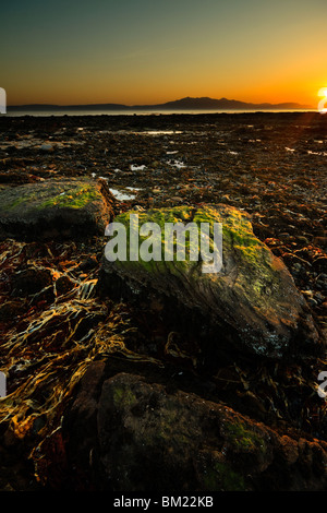 Coucher de soleil sur la plage d'Ardrossan vu de l'Arran Banque D'Images