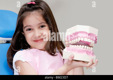 Portrait of a Girl holding d'un ensemble de prothèses dentaires Banque D'Images