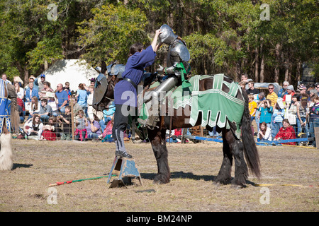 Gainesville FL - janvier 2009 - Groom aide un homme habillé en chevalier à positionner une armure sur le terrain de joute à Hoggetowne Medieval faire Banque D'Images