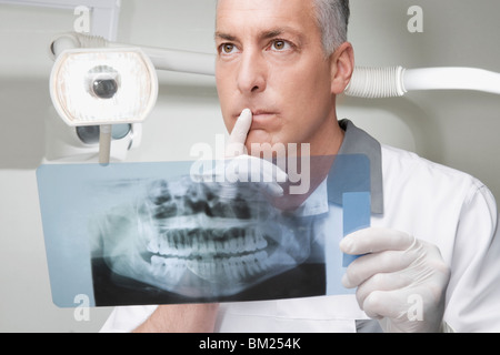 Dentiste l'examen d'une X-Ray report Banque D'Images