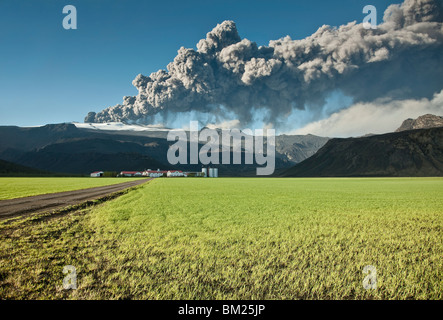 Le nuage de cendres de l'éruption du Eyjafjallajokull en Islande dépassant d'une ferme voisine Banque D'Images