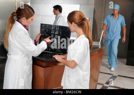 Deux femmes médecins l'examen d'une X-Ray report Banque D'Images