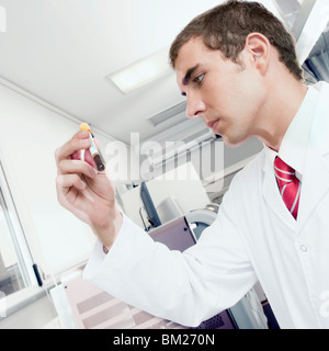 Technicien de laboratoire à l'essai un échantillon de sang dans un tube à essai Banque D'Images