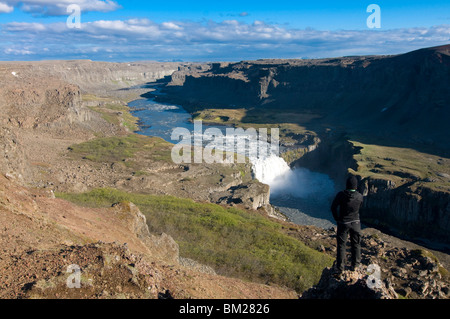 Young woman enjoying view plus de gorges et de cratères de volcan rempli d'eau, Jokulsarglijufur Dettifoss, Islande, régions polaires Banque D'Images