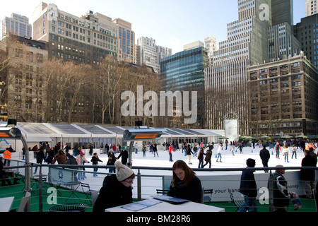 Les gens assis dans un café à côté de la patinoire de Bryant Park, New York City, New York State, USA Banque D'Images