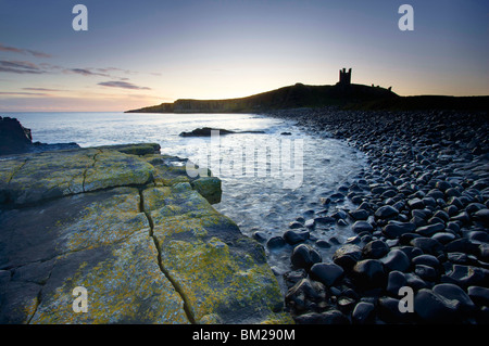 Vue sur le Churn Rumble à l'aube vers les ruines du château de Dunstanburgh, Embleton Bay, Northumberland, Angleterre Banque D'Images