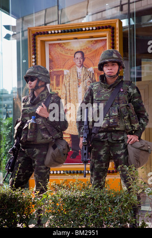 Un portrait du roi dans le hall d'entrée de la tour de l'ITF, Silom Road, donne sur les soldats qui y est affiché. Banque D'Images