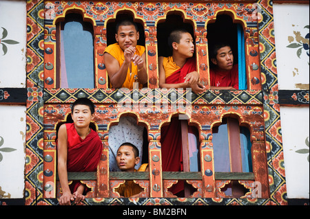 Les jeunes moines à une fenêtre, Chimi Lhakhang datant de 1499, le Temple du Lama Drukpa Kunley fou divin, Punakha, Bhoutan Banque D'Images