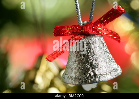 Silver Bell dans l'arbre de Noël avec ruban rouge, carte xtmas Banque D'Images