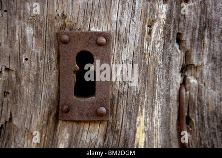 Trou de serrure sur de vieux bois gris, métal rouillé Banque D'Images