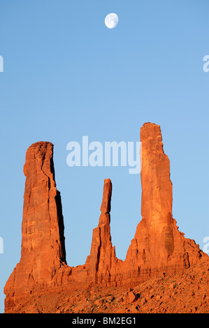 Monument Valley - Trois Soeurs au lever du soleil et lune avec réglage, l'Arizona et l'Utah, USA Banque D'Images