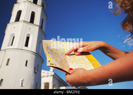 Femme debout à l'extérieur de la cathédrale de Vilnius Beffroi avec carte, Vilnius, Lituanie, Pays Baltes Banque D'Images