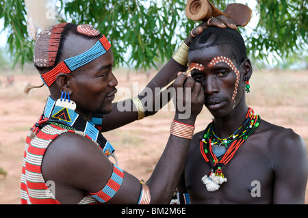 Deux hommes de la tribu Hamer la préparation pour le saut du taureau cérémonie, vallée de l'Omo, dans le sud de l'Éthiopie, de l'Éthiopie Banque D'Images