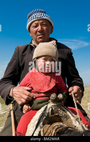 Grand-père avec son petit-fils un cheval, chanson Kul, Kirghizistan Banque D'Images