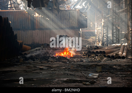 Grande usine et d'entrepôt s'est écroulé et la combustion lente après incendie majeur avant - Fire Brigade de nuit vers le bas d'amortissement Banque D'Images