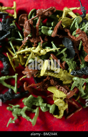 Métaphore du jouet en plastique soldats morts de guerre sur un fond rouge sang Banque D'Images