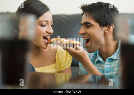 Close-up d'un couple de manger une pointe de pizza Banque D'Images
