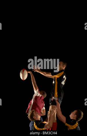 Rugby players Competing for ball dans l'air Banque D'Images