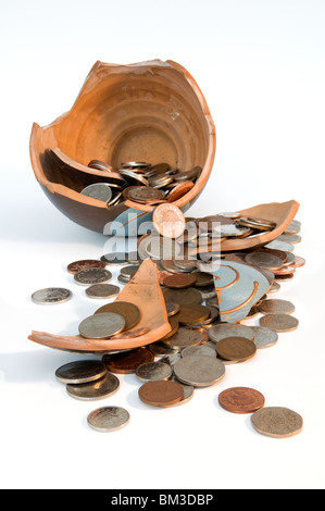 Broken terramundi pot d'épargne avec de l'argent s'échappe au-dessus de la table sur un fond blanc. Banque D'Images