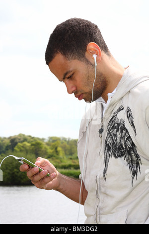 Footballeur professionnel Ben Fairclough à écouter de la musique sur un lecteur MP3 Ipod. Banque D'Images