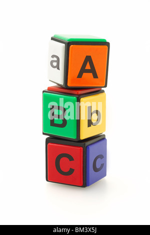Alphabet blocks colorés empilés sur fond blanc Banque D'Images
