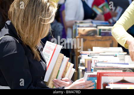 Une femme choisir des livres à une vente de livres Banque D'Images