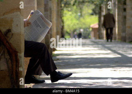 Un homme de la lecture d'un document dans le jardin National d'Athènes, Grèce. Banque D'Images