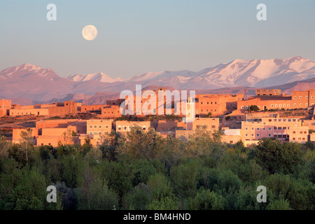 La pleine lune se couche sur les montagnes de l'Atlas derrière Boumalne du Dadès dans la vallée du Dadès du Maroc Banque D'Images