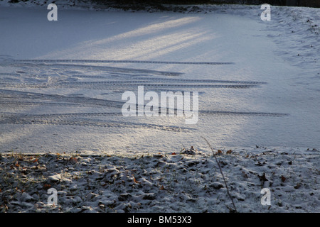 Les premières traces de pneu dans la neige vierge du jour au lendemain dans un parking d'entreprise en Finlande Banque D'Images