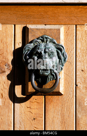 Un Lions Head Heurtoir sur une porte extérieure en bois dans le village de Sutton Veny près de Salisbury Wiltshire, Royaume-Uni Banque D'Images