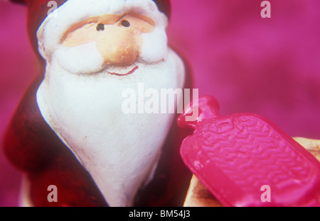 Close up of model d'un père noël souriant à la vue des bouteille d'eau chaude Banque D'Images