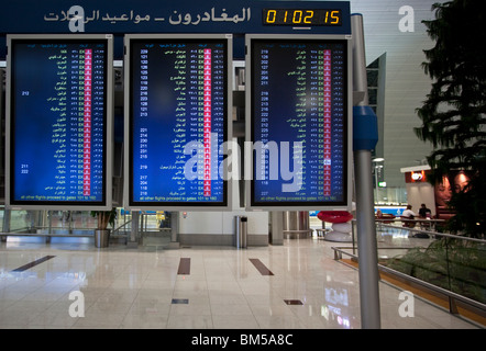 Départ bord indiquant destinations en langue arabe et de l'écriture, l'aéroport International de Dubai DXB Banque D'Images