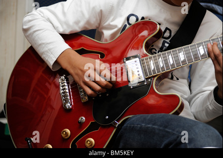 Garçon jouer guitare jazz Aria Banque D'Images