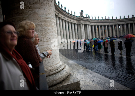 Les femmes âgées se tenir sous les colonnes de la Place Saint Pierre, qui attendent d'entrer dans la Basilique Saint-Pierre, Vatican, Rome Banque D'Images