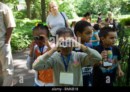 Les étudiants de première année rendez-vous l'observation des oiseaux dans Central Park à New York avec des jumelles Banque D'Images