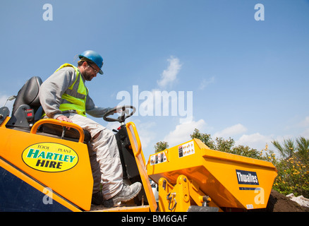 Un constructeur de conduire un camion dumper mini sur une maison, extension d'emploi bâtiment, Ambleside, Cumbria, Royaume-Uni. Banque D'Images