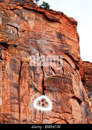 Un alpiniste dans Zion National Park, Utah (encerclé) est presque inaperçue contre la paroi transparente. Banque D'Images