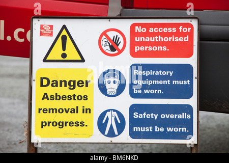 Un spécialiste de l'enlèvement de l'amiante société Suppression d'amiante sur un toit en appentis d'une maison à Ambleside, Cumbria, Royaume-Uni. Banque D'Images