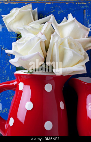 Les roses blanches en rouge pitcher Banque D'Images