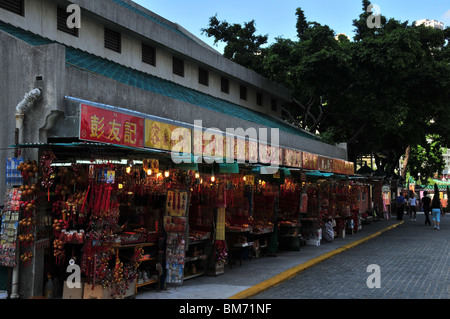 Vue oblique de 10 stalles, éclairé par les lumières électriques, de vendre de l'encens à l'entrée du Temple Wong Tai Sin, Hong Kong Banque D'Images