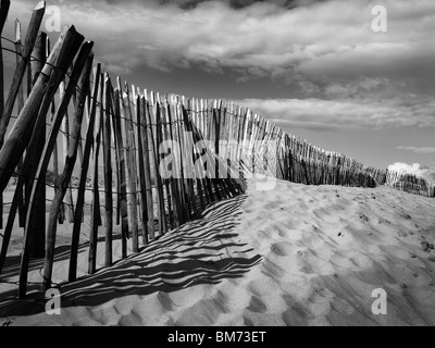 Dunes de sable de Formby Point près de Liverpool sur la côte de Merseyside, clôture, montrant des traces de pas dans le sable en noir et blanc Banque D'Images