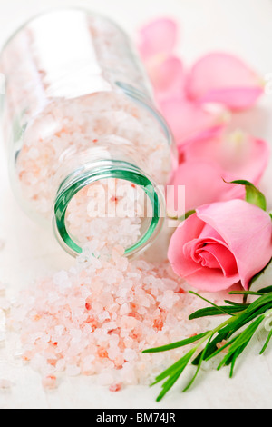 Sels de bain rose dans un bocal en verre avec des fleurs et des herbes Banque D'Images