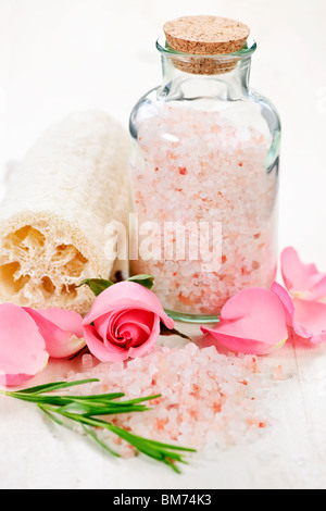 Sels de bain rose dans un bocal en verre avec des fleurs et des herbes Banque D'Images