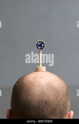 Un homme avec un mini rond-point, signe de route sur la tête Banque D'Images