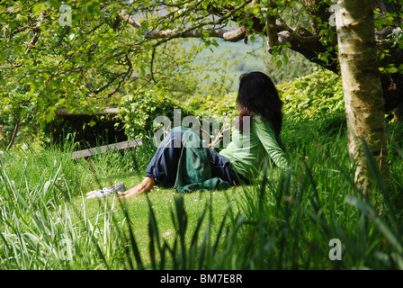 Femme méditant dans les jardins de Chalice Well Somerset Glastonbury Angleterre Royaume-Uni Banque D'Images