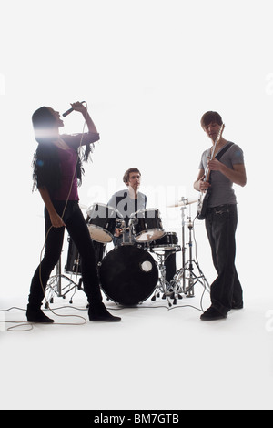 Un batteur, guitariste et chanteur de la scène, Studio shot, fond blanc, éclairage arrière Banque D'Images