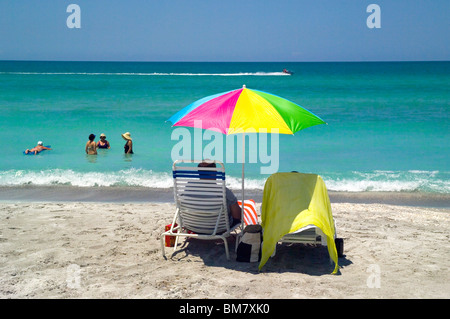 Les vacanciers à terre regarder leurs amis de soleil dans le golfe du Mexique chaudes eaux turquoise le long de la plage de Longboat Key à Sarasota, Floride, USA. Banque D'Images